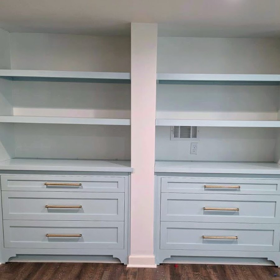 Matching built-in dressers with open shelving flanking a support column