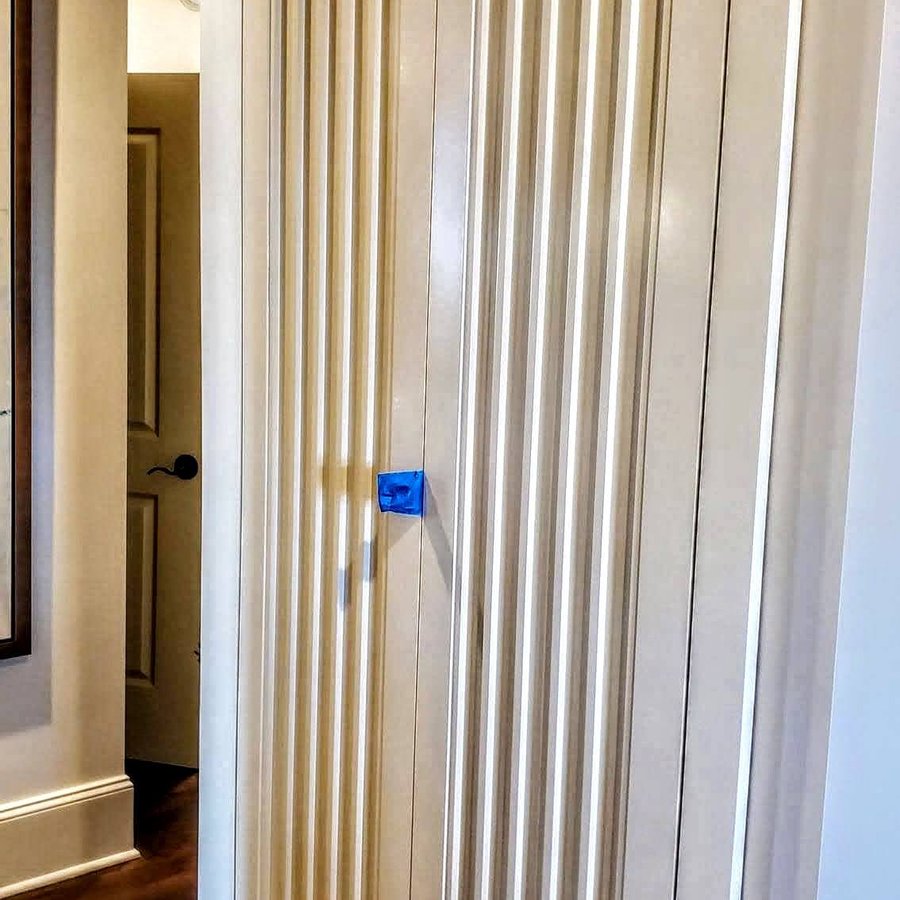 Tall fluted closet doors with a cream painted finish