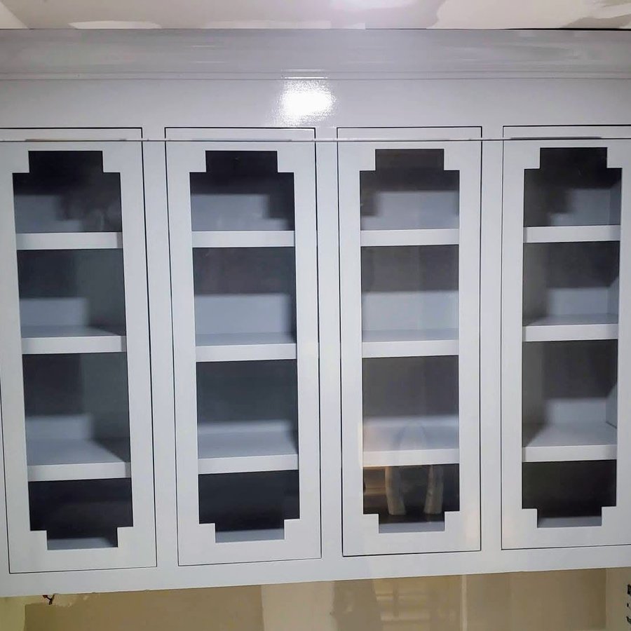 Glass-front upper cabinetry with a geometric mullion pattern