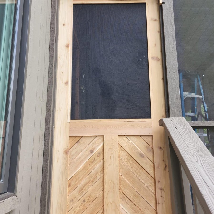 Custom cedar screen door with a chevron panel base, under construction