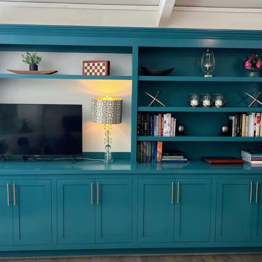 Wide teal built-in media console and bookshelf combination unit